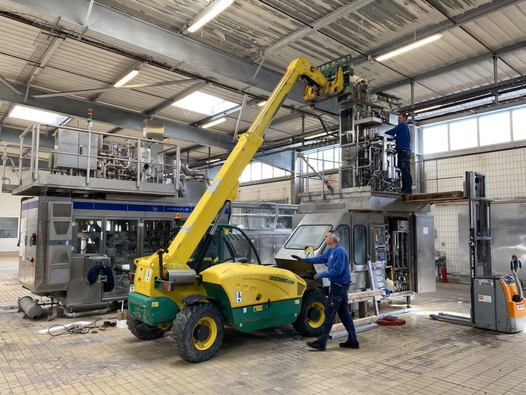 Telescopic handler moving a machine inside the workshop